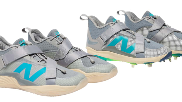 Side view of grey and blue New Balance baseball cleats and shoes.